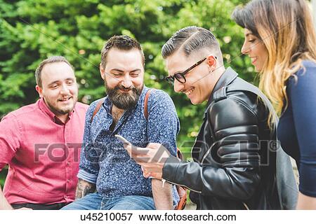 Group of friends looking at message on cellphone View Large Photo Image Stock Photo - Group of friends looking at message on cellphone. Fotosearch