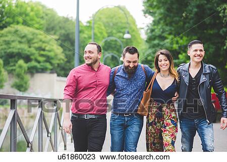Group of friends walking in park View Large Photo Image Stock Image - Group of friends walking in park. Fotosearch