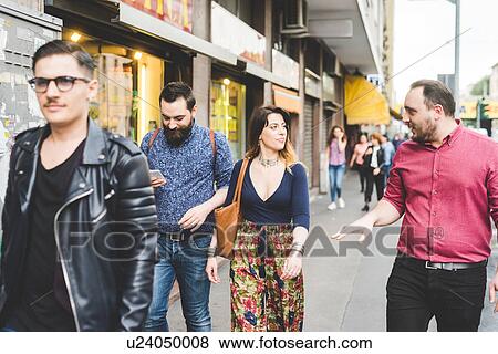 Group of friends walking on sidewalk View Large Photo Image Stock Photo - Group of friends walking on sidewalk. Fotosearch