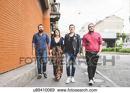 Stock Photo - Group of friends walking on sidewalk. Fotosearch
