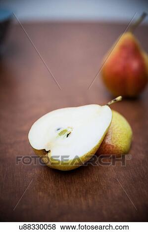Stock Photo - Halved pear on wooden table. Fotosearch