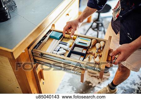 Hand reaching into open drawer containing equipment and materials in book arts workshop View Large Photo Image Stock Image - Hand reaching into open drawer containing equipment and materials in book arts workshop. Fotosearch