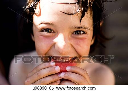 Stock Photography - Happy boy eating watermelon on summer day. Fotosearch