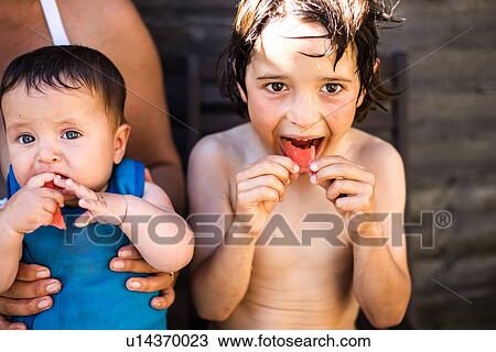 Happy brothers eating watermelon on summer day View Large Photo Image Stock Image - Happy brothers eating watermelon on summer day. Fotosearch