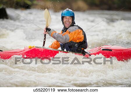 Stock Photo - Happy male kayaker paddling River Dee rapids. Fotosearch