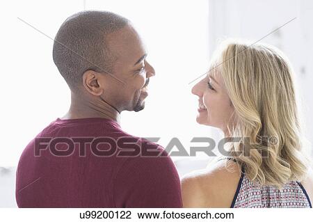 Happy multi ethnic couple looking at each other View Large Photo Image Stock Image - Happy multi ethnic couple looking at each other. Fotosearch