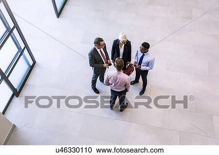 High angle view of businesswoman and men having discussion in office atrium View Large Photo Image Stock Image - High angle view of businesswoman and men having discussion in office atrium. Fotosearch