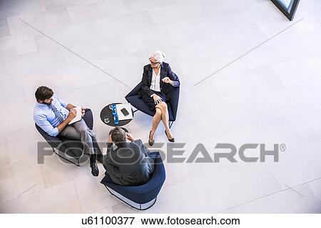 High angle view of businesswoman and men meeting in office atrium View Large Photo Image Stock Photo - High angle view of businesswoman and men meeting in office atrium. Fotosearch
