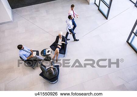 High angle view of businesswoman and men meeting in office atrium View Large Photo Image Stock Photograph - High angle view of businesswoman and men meeting in office atrium. Fotosearch