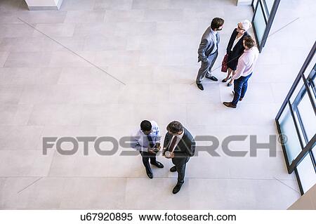 High angle view of businesswoman and businessmen having discussions in office atrium View Large Photo Image Stock Photography - High angle view of businesswoman and businessmen having discussions in office atrium. Fotosearch