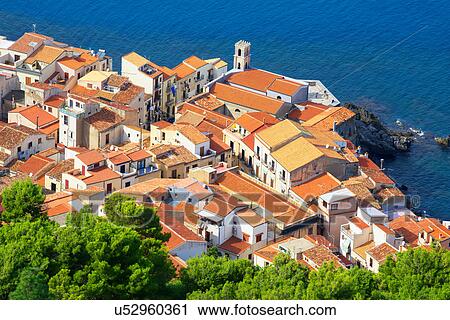 Stock Image - High angle view of Cefalu terracotta rooftops and coast from La Rocca, Sicily, Italy. Fotosearch
