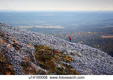 Stock Photo - Hiker ascending rocky steep hill, Kesankitunturi, Lapland, Finland. Fotosearch