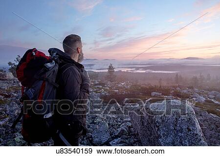 Hiker enjoying sunset on cliff top, Sarkitunturi, Lapland, Finland View Large Photo Image Stock Photo - Hiker enjoying sunset on cliff top, Sarkitunturi, Lapland, Finland. Fotosearch