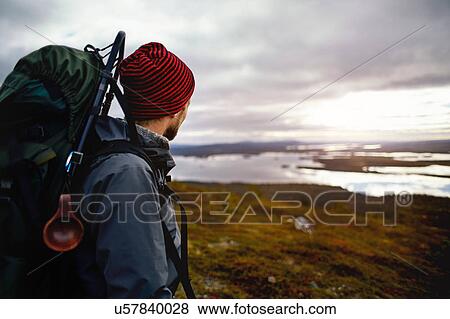 Stock Photo - Hiker enjoying view of lake, Keimiotunturi, Lapland, Finland. Fotosearch