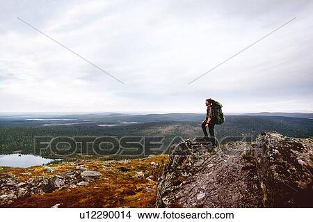 Hiker enjoying view on cliff top, Keimiotunturi, Lapland, Finland View Large Photo Image Picture - Hiker enjoying view on cliff top, Keimiotunturi, Lapland, Finland. Fotosearch