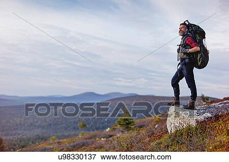 Stock Photo - Hiker enjoying view on rock, Keimiotunturi, Lapland, Finland. Fotosearch