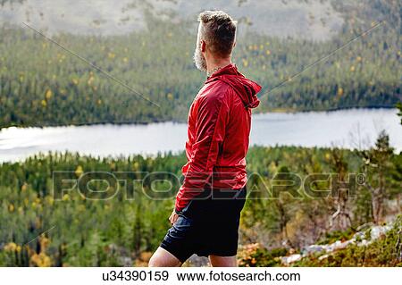 Stock Photo - Hiker enjoying view on steep hill, Kesankitunturi, Lapland, Finland. Fotosearch
