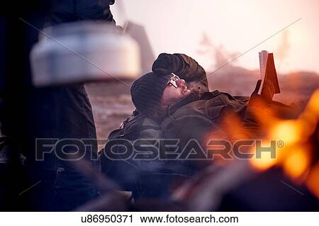 Stock Image - Hiker resting by campfire, Sarkitunturi, Lapland, Finland. Fotosearch