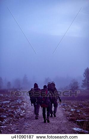 Stock Photo - Hikers crossing rocky field at dusk, Sarkitunturi, Lapland, Finland. Fotosearch