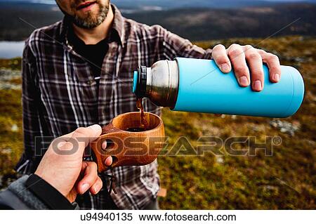 Stock Photography - Hikers having coffee on cliff top, Keimiotunturi, Lapland, Finland. Fotosearch