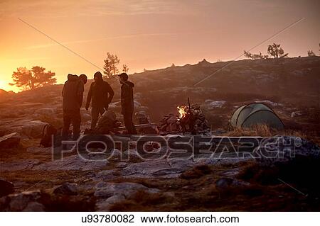 Stock Image - Hikers preparing for camp at sunset, Sarkitunturi, Lapland, Finland. Fotosearch