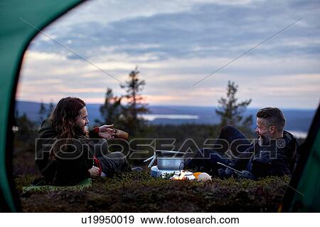 Stock Photo - Hikers relaxing, chatting in front of tent, Keimiotunturi, Lapland, Finland. Fotosearch
