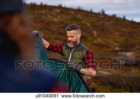 Stock Image - Hikers setting up tent, Keimiotunturi, Lapland, Finland. Fotosearch
