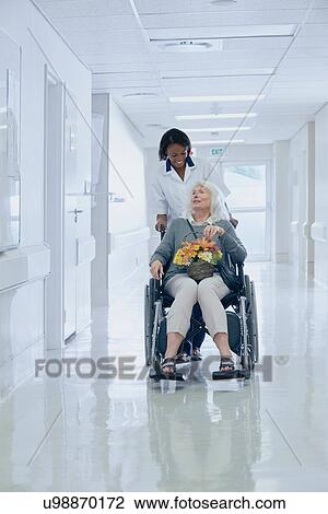 Hospital orderly pushing senior female patient in wheelchair View Large Photo Image Stock Image - Hospital orderly pushing senior female patient in wheelchair. Fotosearch