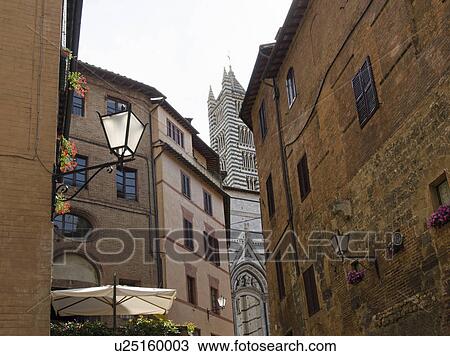 Stock Image - Italy, Siena, View of street in old town with Duomo di Siena in background. Fotosearch