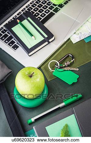 Stock Image - Laptop, notebook, folding map and green apple on table. Fotosearch