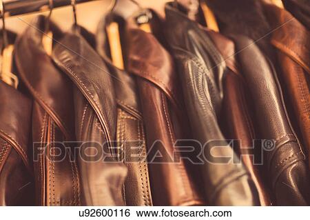 Stock Photograph - Leather jackets hanging in a row, in leather jacket manufacturers, close-up. Fotosearch