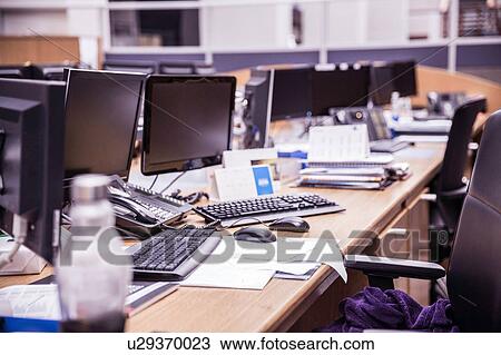 Stock Image - Long office desk with rows of desktop computers. Fotosearch