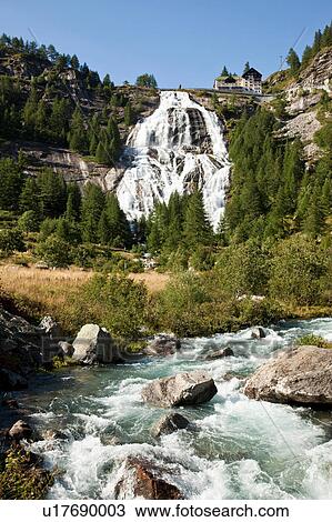 Stock Image - Low angle view of Toce waterfall cascading down rock face in Formazza valley, Piedmont, Italy. Fotosearch