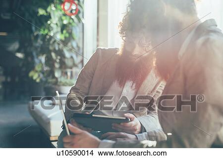 Male adult hipster twins working on digital tablet and laptop in office View Large Photo Image Picture - Male adult hipster twins working on digital tablet and laptop in office. Fotosearch