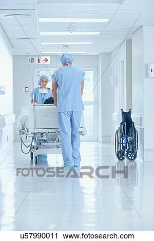 Male and female nurses pushing bed on hospital corridor View Large Photo Image Stock Image - Male and female nurses pushing bed on hospital corridor. Fotosearch
