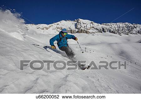 Stock Image - Male freestyle skier skiing down steep mountainside, Zugspitze, Bayern, Germany. Fotosearch
