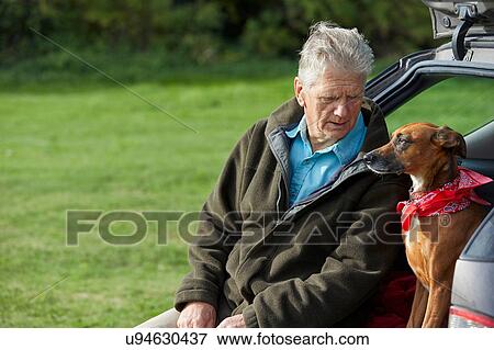 Stock Photo - Man and dog sitting in car boot. Fotosearch
