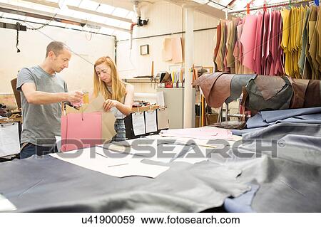 Stock Photo - Man and woman having discussion in leather jacket manufacturers. Fotosearch