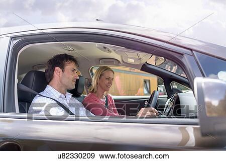 Stock Photo - Man and woman in electric car. Fotosearch