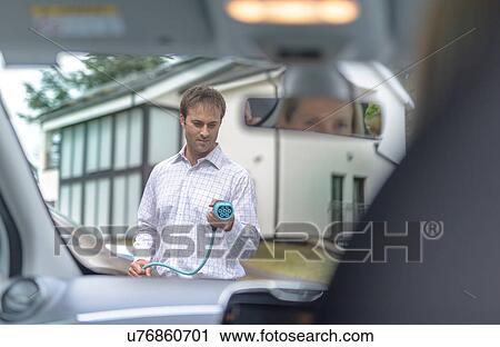 Man charging electric car, seen through car interior View Large Photo Image Stock Image - Man charging electric car, seen through car interior. Fotosearch