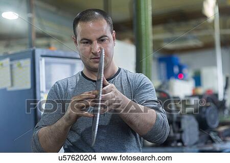 Man checking rotary blade in workshop View Large Photo Image Picture - Man checking rotary blade in workshop. Fotosearch