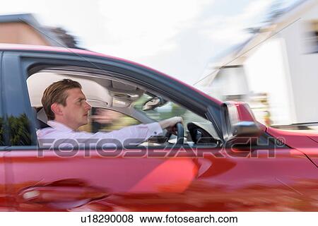 Stock Photo - Man driving electric car. Fotosearch