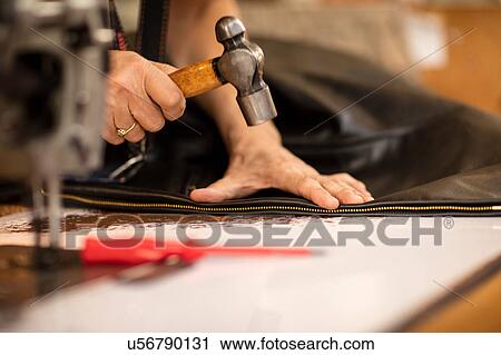 Man hammering zip on jacket in leather jacket manufacturers, close-up View Large Photo Image Stock Image - Man hammering zip on jacket in leather jacket manufacturers, close-up. Fotosearch