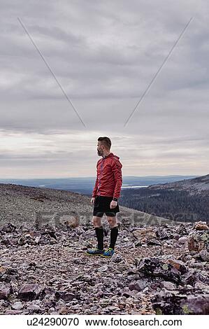 Man looking back on rocky cliff top, Kesankitunturi, Lapland, Finland View Large Photo Image Stock Image - Man looking back on rocky cliff top, Kesankitunturi, Lapland, Finland. Fotosearch