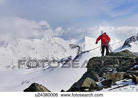 Man on top of snow covered mountain throwing climbing rope, Saas Fee, Switzerland View Large Photo Image Stock Photograph - Man on top of snow covered mountain throwing climbing rope, Saas Fee, Switzerland. Fotosearch