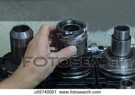 Stock Image - Man preparing grinding machine. Fotosearch