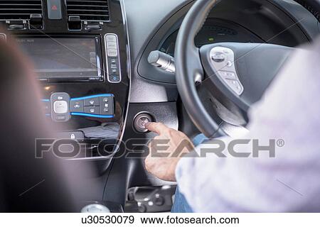Man pressing start button on electric car, close up View Large Photo Image Stock Photo - Man pressing start button on electric car, close up. Fotosearch