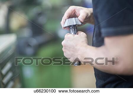 Stock Image - Man repairing machinery part. Fotosearch