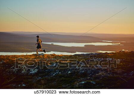 Man running on cliff top at sunset, Keimiotunturi, Lapland, Finland View Large Photo Image Stock Image - Man running on cliff top at sunset, Keimiotunturi, Lapland, Finland. Fotosearch
