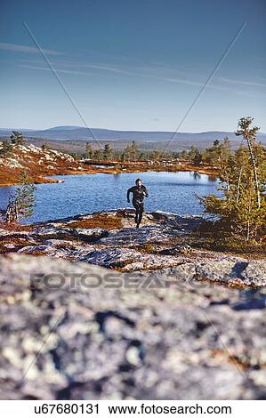 Man running on the bank of lake, Sarkitunturi, Lapland, Finland View Large Photo Image Stock Image - Man running on the bank of lake, Sarkitunturi, Lapland, Finland. Fotosearch